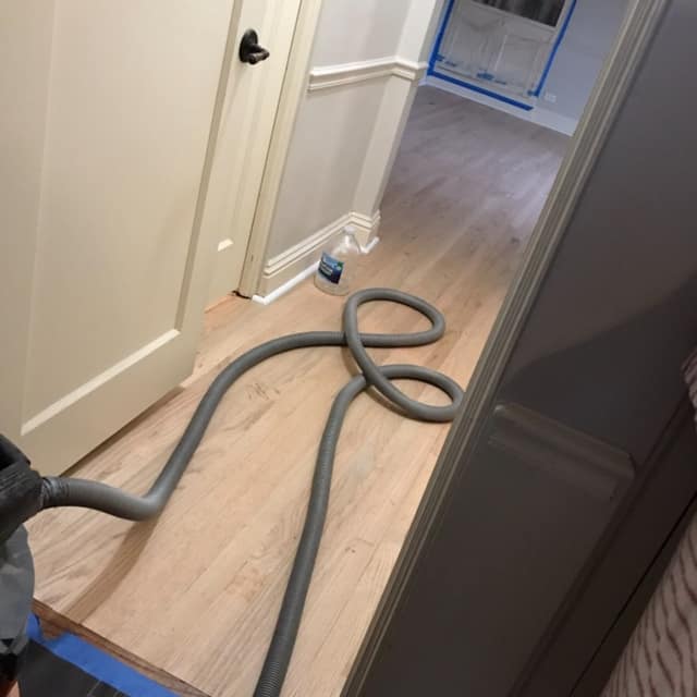 Hallway floor freshly sanded, mid-refinish