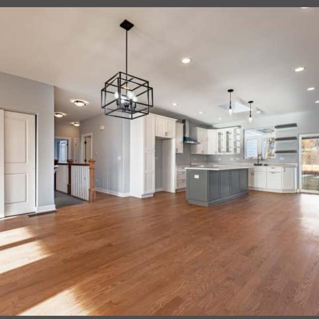 Open-plan living room and kitchen with a refinished hardwood floor