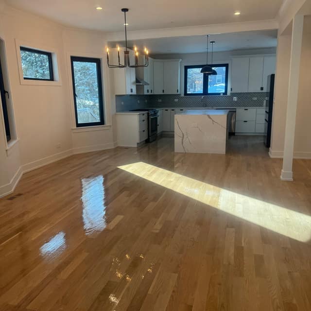 Freshly finished golden hardwood floor catching the sunlight