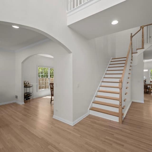Foyer and staircase with light wood-tone flooring