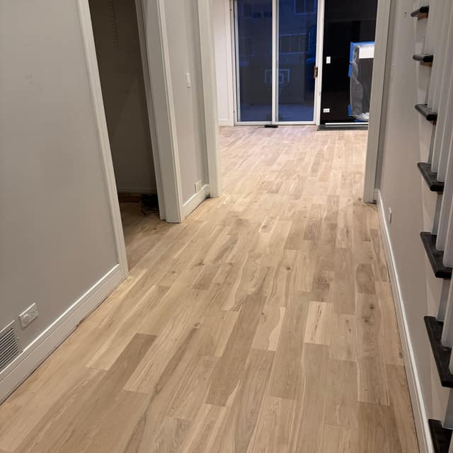 Newly installed wide-plank wood floor before finishing