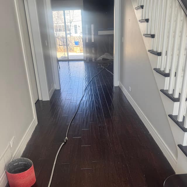 Dark espresso wood floor in a hallway, mid-project