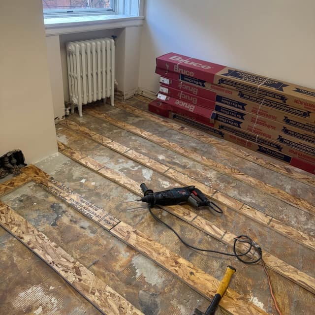 Floor repair in progress — subfloor rebuilt with new hardwood staged to install